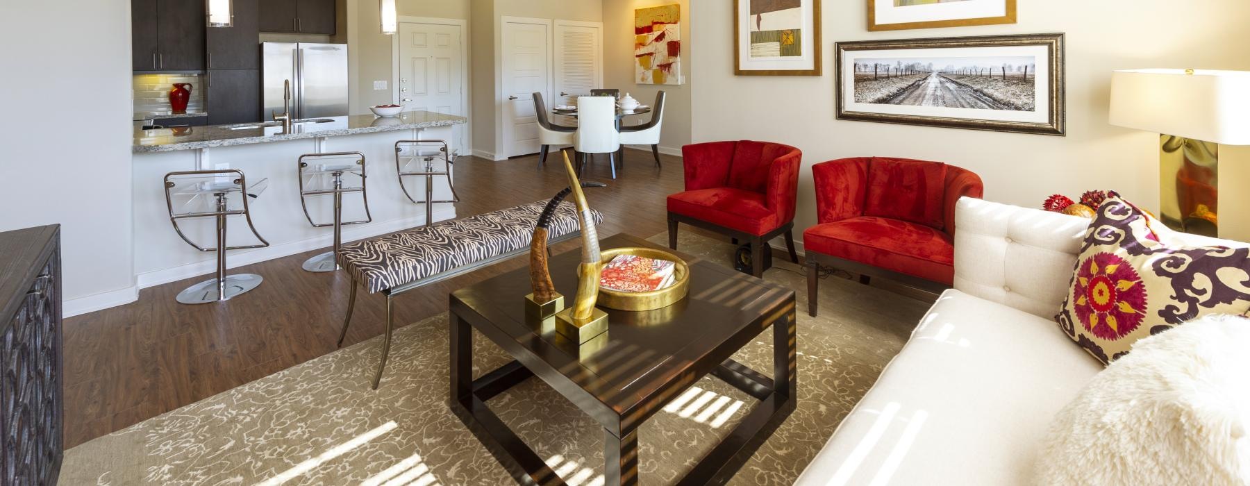 a living room with a couch a table chairs and a breakfast bar