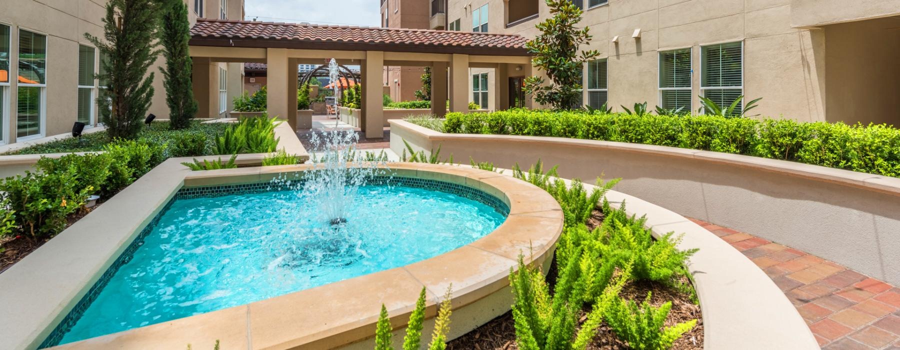 a fountain in a courtyard between buildings