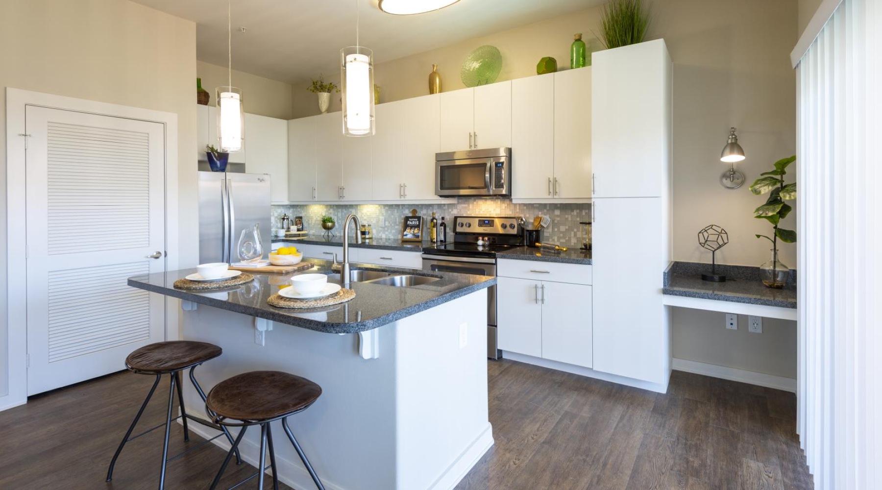 a kitchen with a kitchen island with bar stools